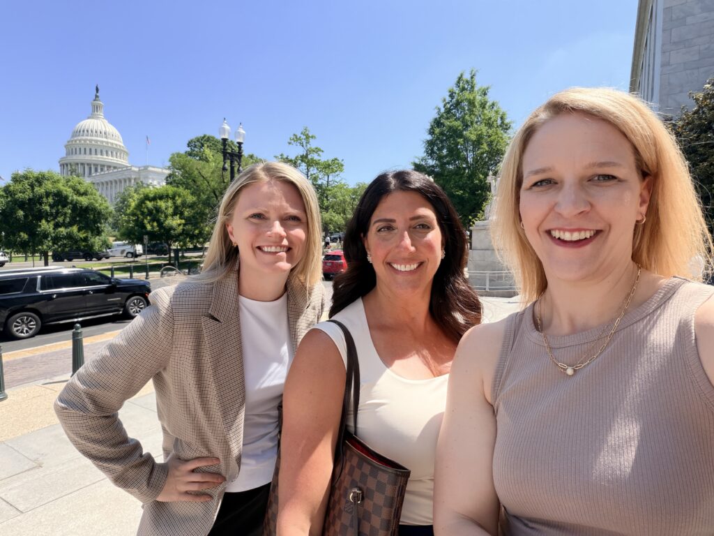 Selfie of three women smiling with the US Capitol building in the background