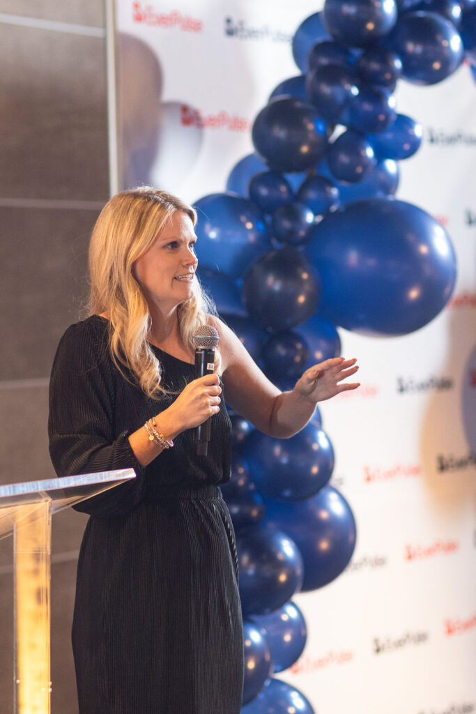 Woman speaking into a microphone at the EverPulse fundraiser