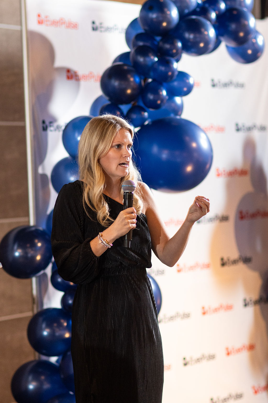 Speaker addressing guests with a microphone at the EverPulse fundraiser